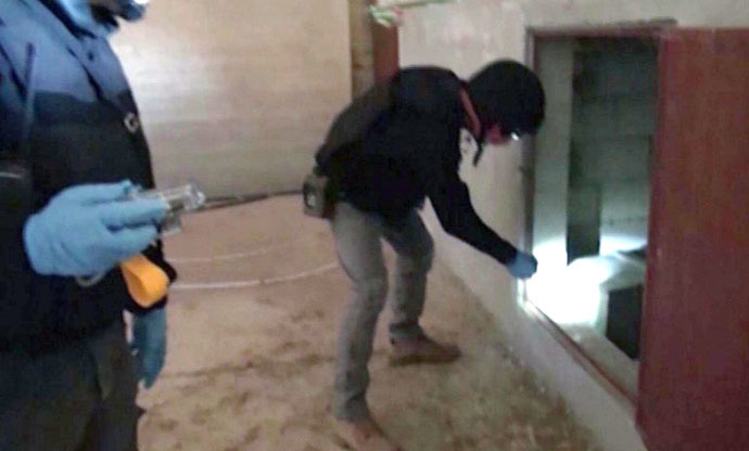 An image grab taken from Syrian television on October 10, 2013 shows inspectors from the Organisation for the Prohibition of Chemical Weapons (OPCW) at work at an undisclosed location in Syria. (AFP Photo)