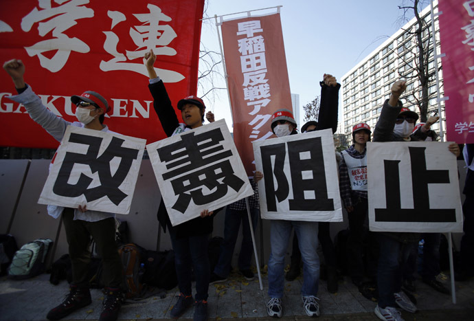 Protesters raise their fists as they shout slogans during a rally against the government's planned state secrets act in front of the parliament building in Tokyo November 26, 2013. (Reuters/Toru Hanai