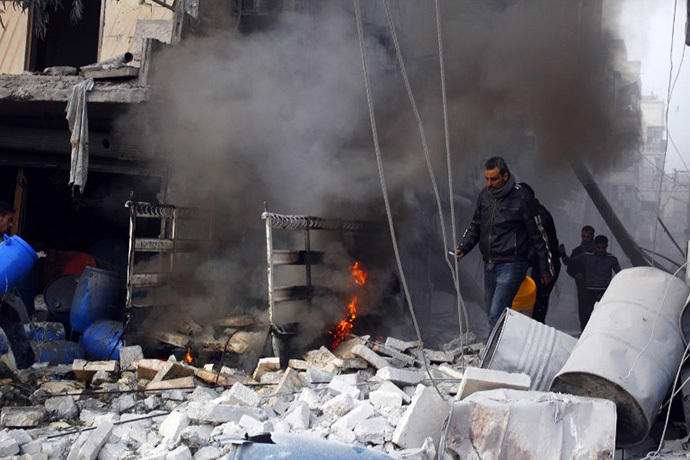 Rebels and civilians make their way through the debris after an air strike by pro-government forces on the Syrian city of Aleppo on November 28, 2013. (AFP Photo / Mohammed Al-Khatieb)