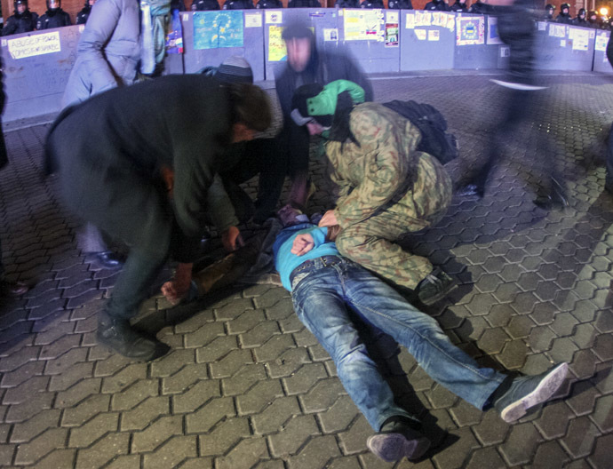 People help a protester after a scuffle with the police during a demonstration in support of EU integration at Independence Square in Kiev November 30, 2013. (Reuters)