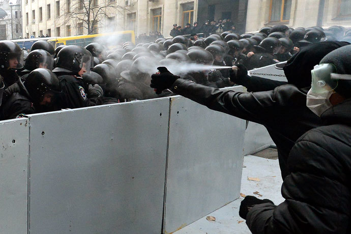 Pro-European Ukrainian demonstrators spray tear gas on police members protecting the presidential adminstration office in Kiev as 100 000 outraged Ukrainians swarmed the city in a call for early elections meant to punish authorities for rejecting a historic EU pact, on December 1, 2013.( AFP Photo / Vasily Maximov)