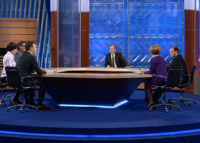 Prime Minister Dmitry Medvedev (center) gives an interview on the round-up of the Governmentâs work in 2013 to federal TV channels at the Ostankino TV Center. (RIA Novosti /Alexander Astafyev)