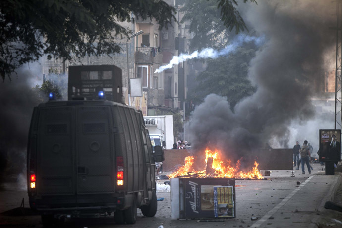 Muslim Brotherhood and ousted president Mohammed Morsi supporters (background) clash with Egyptian riot police during a demonstration in the streets of El Zeitun neighborhood close by al Qubba presidential Palace on December 6, 2013 in Cairo. (AFP Photo/Mahmoud Khaled)
