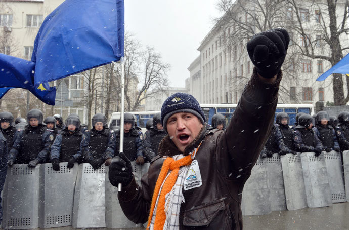 A protester with holding an EU flag shouts slogans in front of riot police during a picket held outside the presidential office in Kiev on December 7, 2013.(AFP Photo / Sergei Supinsky)