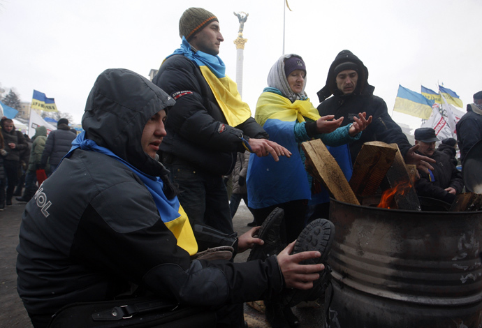 Protesters warm themselves at the camp of the opposition on Maiden (Independence) Square in Kiev on a frosty day in Kiev on December 10, 2013. (AFP Photo / Yuriy Kirnichny)