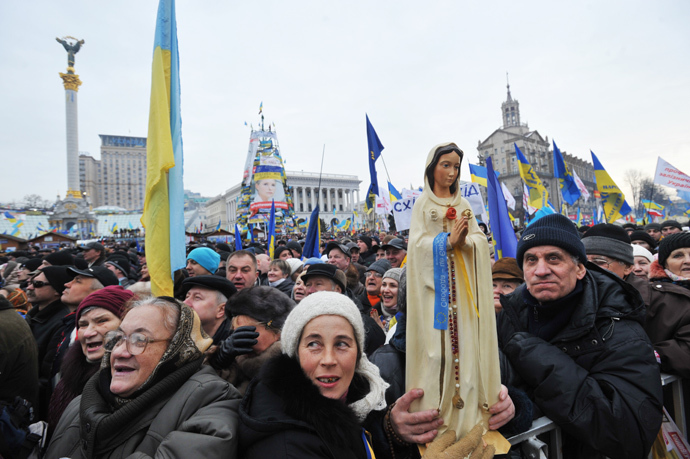 A protestor holds a statue of Virgin Mary during a mass rally of the opposition Independence Square in Kiev on December 15, 2013. (AFP Photo / Genya Savilov)