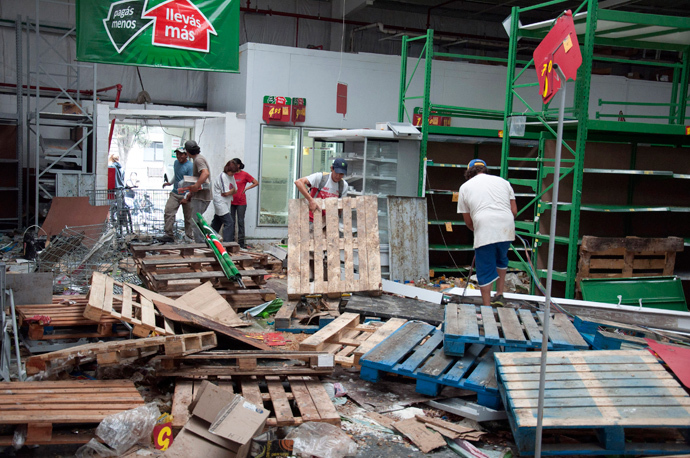 Residents look for goods amid a ransacked shop after it was looted in the northern Argentine province of Tucuman December 10, 2013. (Reuters / Paloma Cortes Aysua)