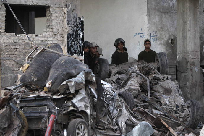 Police officers stand near damaged vehicles outside the building of Directorate of Security after an explosion in Egypt's Nile Delta town of Dakahlyia, about 120 km (75 miles) northeast of Cairo December 24, 2013. (Reuters/Mohamed Abd El Ghany)
