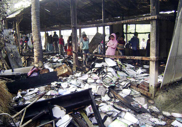 People look at burnt textbooks after a primary school which was supposed to be used as a polling booth was set on fire, in Feni January 4, 2014. (Reuters)