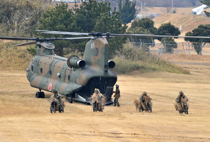 Japanese Ground Self Defense forces' airbourne troop personnel riding on their motorcycles run out from a CH-47 helicopter during the new year exercise in Narashino in Chiba prefecture, suburban Tokyo on January 12, 2014 (AFP Photo / Yoshikazu Tsuno)