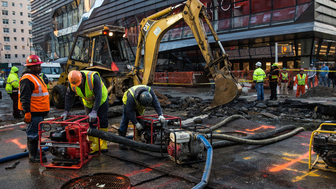 Workers use generators to pump water out of a hole in the street, caused by a water main break on 5th Ave and 13th St. on January 15, 2014 in New York City. (AFP Photo / Andrew Burton)