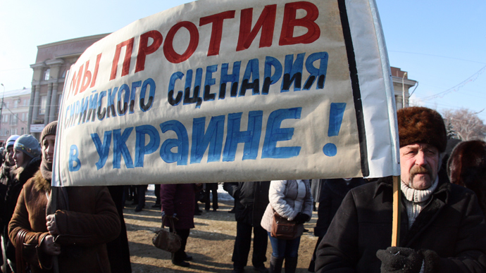 People hold a sign reading ""We are against the Syrian scenario!" as they take part in a demonstration rally in support of the Ukrainian President, in the industrial city of Makeyevka, in the Donetsk industrial region, on January 25, 2014 (AFP Photo / Alexander Khudoteplov)
