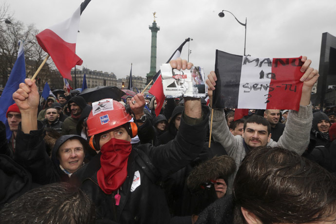 A demonstrator displays a leaflet which reads, "Hollande Resign" as several thousand people attend the "Journee de la Colere" (Day of Anger) march in protest of France's President Francois Hollande, in Paris January 26, 2014. (Reuters/Philippe Wojazer)