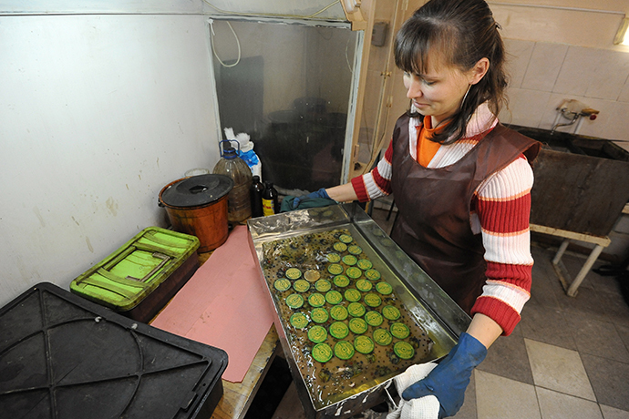 Producing souvenir Olympic medals with fragments from the meteorite in Chelyabinsk at the MAOK art workshop in Zlatoust. (RIA Novosti / Aleksandr Kondratuk)