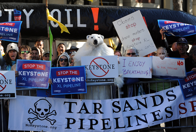 Protesters against the proposed Keystone XL pipeline hold placards across the street from where US President Barack Obama attends a Democratic Party fundraising event in San Francisco, California, on November 25, 2013. (AFP Photo / Jewel Samad)