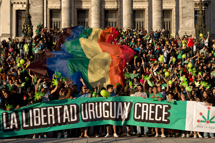 People take part in a demo for the legalization of marijuana in front of the Legislative Palace in Montevideo, on December 10, 2013, as the Senate discuss a law on the legalization of marijuana's cultivation and consumption. (AFP Photo / Pablo Porciuncula)