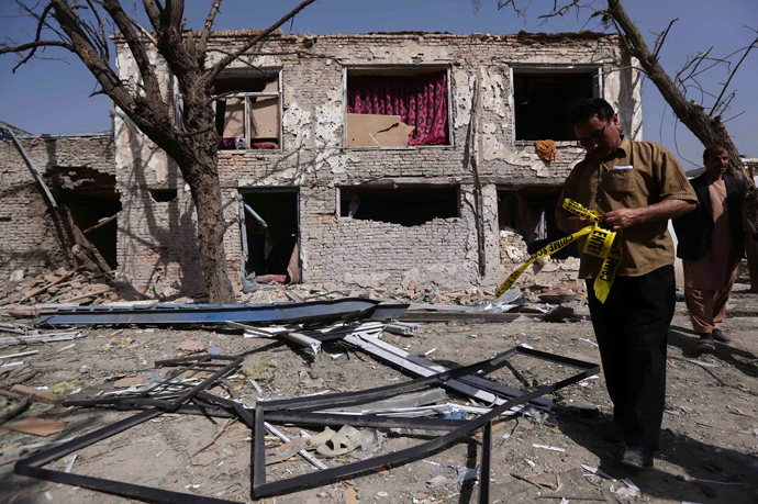 Afghan policeman in civilian clothes tries to secure the scene of an incident in Kabul May 25, 2013 (Reuters / Omar Sobhani)