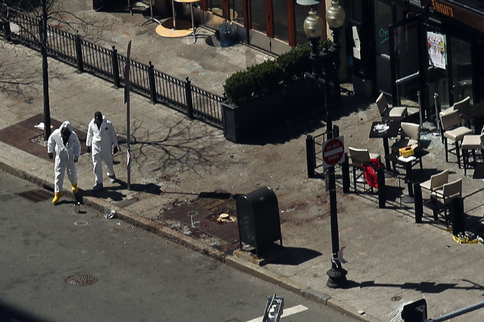 Investigators stand at the scene of twin bombings at the Boston Marathon on April 17, 2013 in Boston, Massachusetts. (Spencer Platt / Getty Images / AFP)