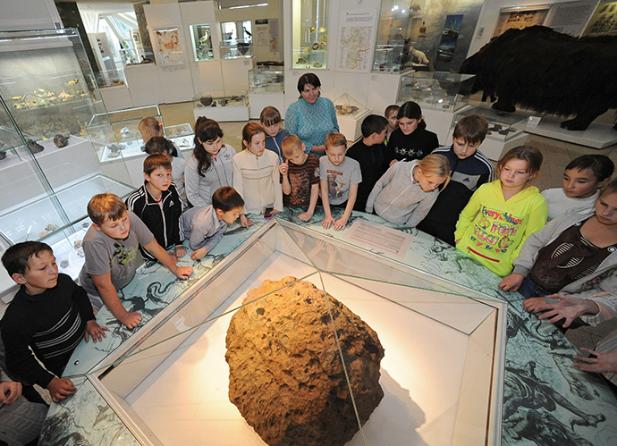 Children look at Chelyabinsk meteorite exhibited at Chelyabinsk Museum of Regional Studies. (RIA Novosti / Aleksandr Kondratuk)