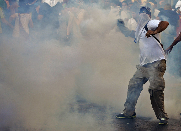Anti-government students throw stones to riot police during a protest, in Caracas on February 15, 2014. ( AFP Photo / Juan Barreto )