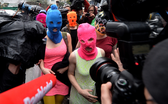 Wearing masks members of Russian punk group Pussy Riot, Nadezhda Tolokonnikova (L) and Maria Alyokhina (R) speak to journalists while leaving the police station of Adler, near Sochi, on February 18, 2014 (AFP Photo / Andrej Isakovic)