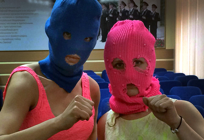Wearing masks members of Russian punk group Pussy Riot, Nadezhda Tolokonnikova (L) and Maria Alyokhina (R), pose for a photo in a police station after their arrest in the Adler district of Sochi, on February 18, 2014.(AFP Photo / Evgeny Feldman)