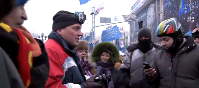 RT video still: Dmitry Zvershovsky (with camera) talks to protesters.