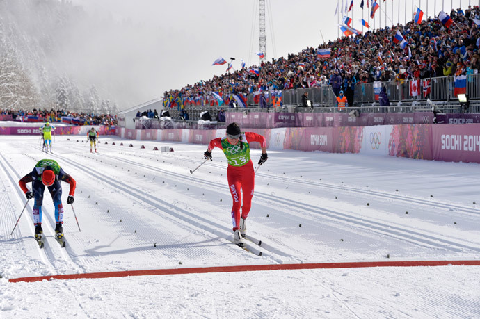 Poland's Justyna Kowalczyk (R) and Russia's Julia Ivanova reach the finish line as they compete in the Women's Cross-Country Skiing Team Sprint Classic Semifinals at the Laura Cross-Country Ski and Biathlon Center during the Sochi Winter Olympics on February 19, 2014 in Rosa Khutor near Sochi. (AFP Photo / Odd Andersen)