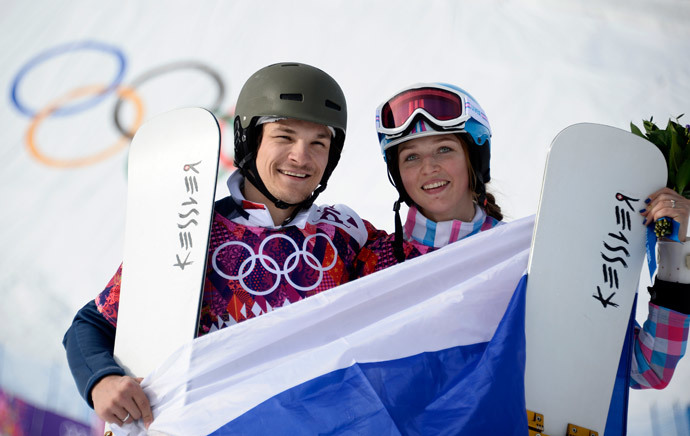 Gold Medallist, Russia's Vic Wild, and his wife, Bronze Medallist Alena Zavarzina, celebrate at the Snowboard Parallel Giant Slalom Flower Ceremony at the Rosa Khutor Extreme Park during the Sochi Winter Olympics on February 19, 2014. (AFP Photo / Franck Fife)