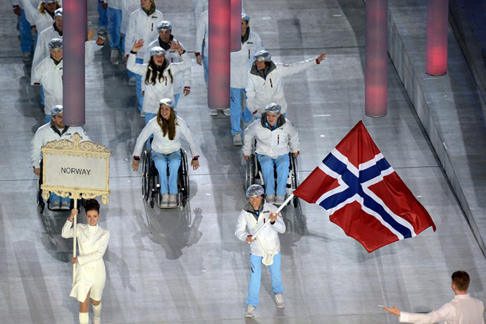 Norwegian paralympic cross-country skier Mariann Marthinsen (C) flies Norway's national flag as she leads the Norwegian delegation into the Fisht Olympic Stadium during the opening ceremony of the 2014 Winter Paralympic Games in the Black Sea resort of Sochi on March 7, 2014. (AFP Photo / Kirill Kudryavtsev)