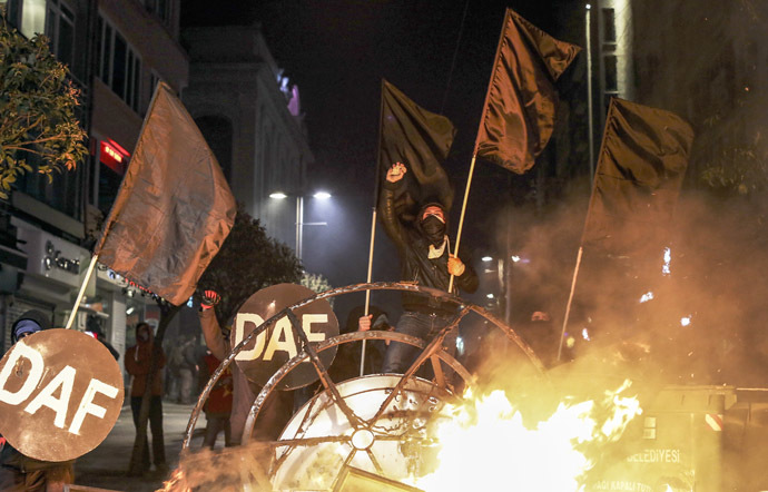Protesters chant slogans behind a barricade during clashes with riot police in Kadikoy, on the Anatolian side of Istanbul, on March 11, 2014. (Reuters)