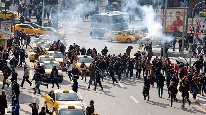 People run as riot police fires tear gas to disperse demonstrators in Ankara March 12, 2014 (Reuters / Umit Bektas)
