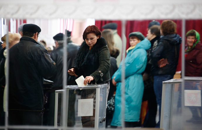 A woman is reflected in a mirror as she casts her ballot during voting in a referendum at a polling station in Simferopol March 16, 2014.(Reuters / Thomas Peter)