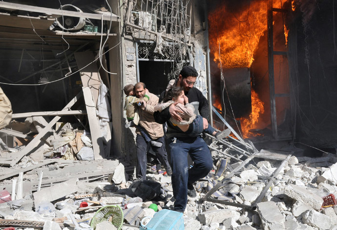Men carrying children run out of a burning building following a barrel bomb attack in the northern Syrian city of Aleppo on February 8, 2014. (AFP Photo / Baraa Al-Halabi)