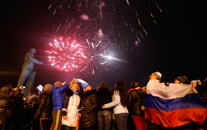 People wave Russian flag as they celebrate the announcement of preliminary results of today's referendum at Lenin Square in the Crimean capital of Simferopol March 16, 2014 (Reuters / Vasily Fedosenko)