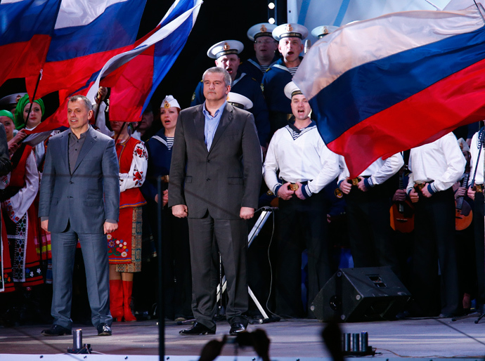 Crimean Prime Minister Sergey Aksyonov (C) stands on a stage as preliminary results of today's referendum are announced on Lenin Square in the Crimean capital of Simferopol March 16, 2014 (Reuters / Thomas Peter)