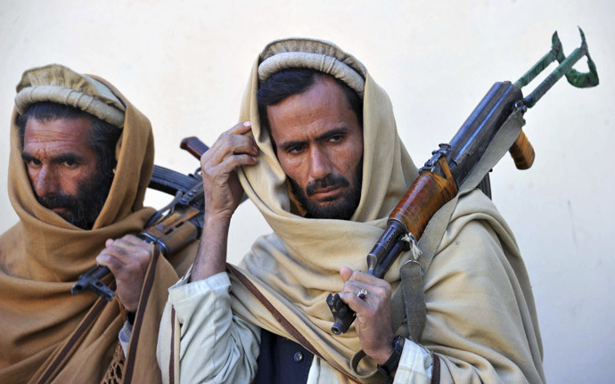 Two former Taliban fighters carry their weapons during a handover as they join a government peace and reconciliation process at a ceremony in Jalalabad, capital of Nangarhar province on January 11, 2014. (AFP Photo / Noorullah Shirzada)