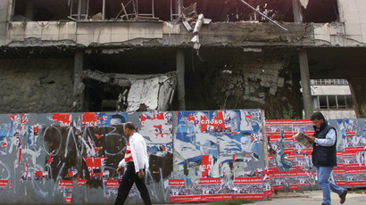 Two local residents walk past the destroyed building housing the defence ministry in central Belgrade 11 October 2000, after it was hit by Allied air raids in Spring 1999. (AFP Photo)