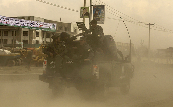 Afghan policemen drive towards an election commission office during an attack by gunmen, in Kabul March 29, 2014. (Reuters / Zohra Bensemra)