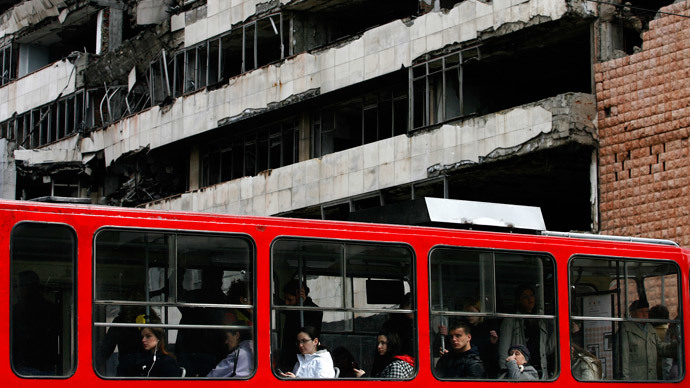 People travel on the tram as they pass a destroyed building of the former federal military headquarters in Belgrade March 24, 2009.(Reuters / Marko Djurica )