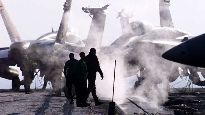 U.S. aviation ordnancemen walk next to three F/A-18 Hornet on the aircraft carrier USS Enterprise in the Adriatic sea January 22, 1999.(Reuters)