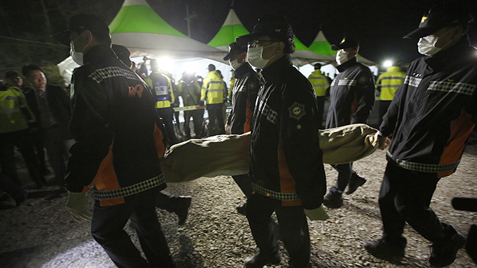 South Korean rescue workers carry the body of a passenger onboard the capsized passenger ship Sewol, at a port where family members of missing passengers are gathered, in Jindo April 19, 2014. (Reuters / Issei Kato)