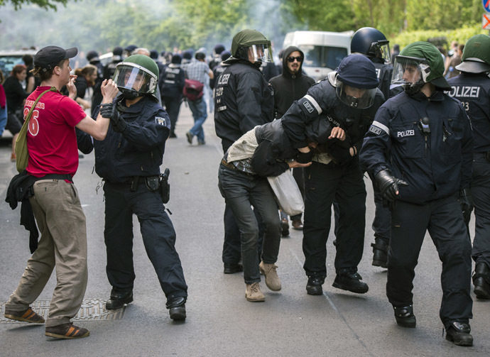 An anti fascist demonstrator (L) is held back as he tries to come to the aid of a fellow protestor being detained as activists from the far right party NPD marched across the Jannowitz bridge in Berlin on April 26, 2014. (AFP Photo/Odd Andersen)