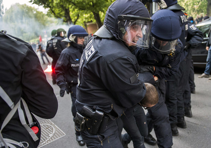 Policemen detain an antifascist protester as activists from the far right party NPD marched across the Jannowitz bridge in Berlin on April 26, 2014. (AFP Photo/Odd Andersen)