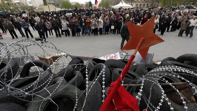 Anti-goverment protesters stand in front of a barricade in front of an occupied building of the Regional State Administration in Donetsk on April 20, 2014.(AFP Photo / Max Vetrov)