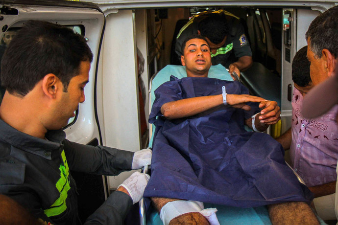 Members of the Egyptian Civil Protection Authority lift an injured man who was wounded during a bomb attack targeting a traffic security post near a courthouse in Cairo's Heliopolis district May 2, 2014. (Reuters / Al Youm Al Saabi Newspaper)
