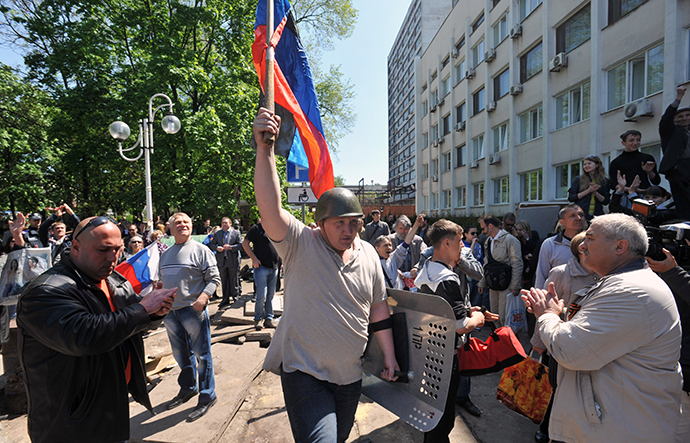 Activists celebrate as Ukrainian policeman leave guarding the state city building in southern Ukrainian city of Mariupol on May 7, 2014. (AFP Photo / Genya Savilov)