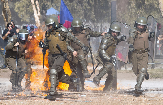 Riot policemen scatter as a molotov cocktail thrown by students falls amid them during a protest against the education system on May 8, 2014 in Santiago. (AFP Photo)