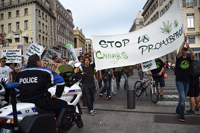 People hold a banner reading "Stop the prohibition" as they face policemen during a protest to call for the legalization of marijuana on May 10, 2014, at the Old Harbour in Marseille, southern France. (AFP Photo / Anne-Christine Poujoulat)
