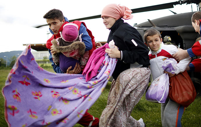 A woman and her children arrive by European Union Force (EUFOR) helicopter after being rescued from the flooded Serici village near Zepce, at a heliport in the central Bosnian town of Zenica, May 17, 2014. (Reuters / Dado Ruvic)